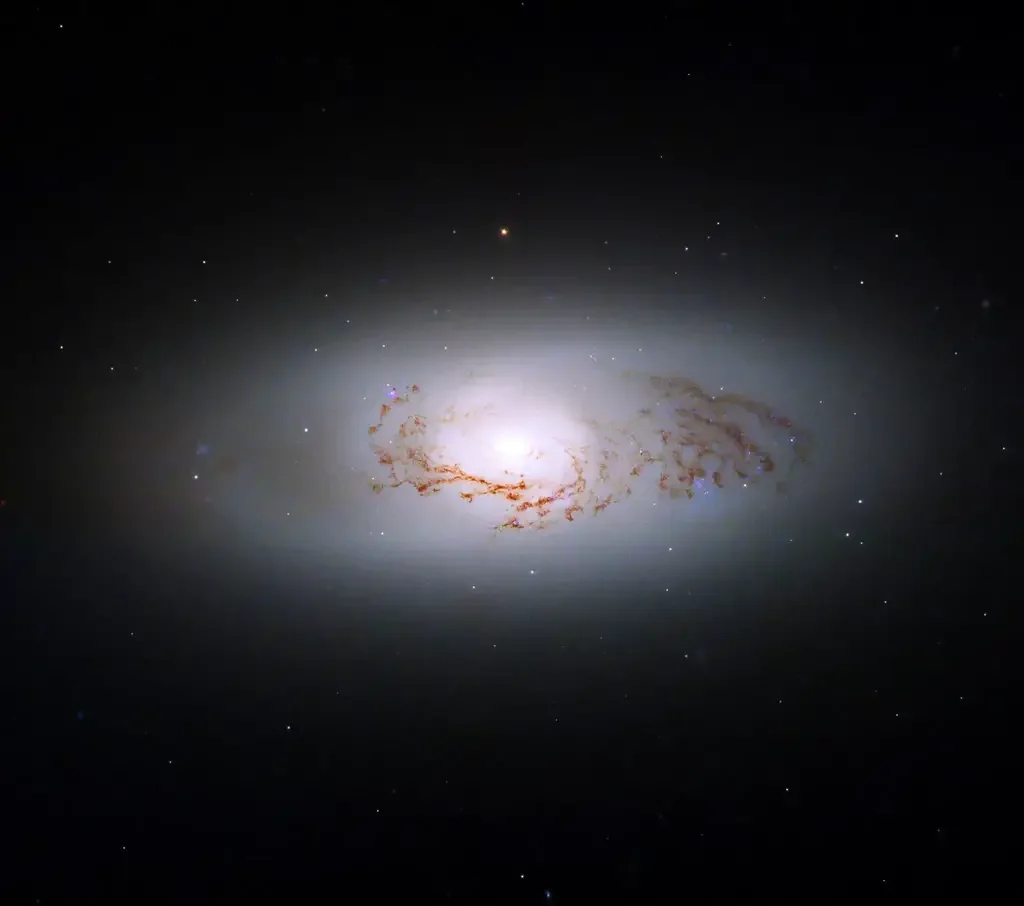 Hubble captura imagem impressionante de raro híbrido galáctico